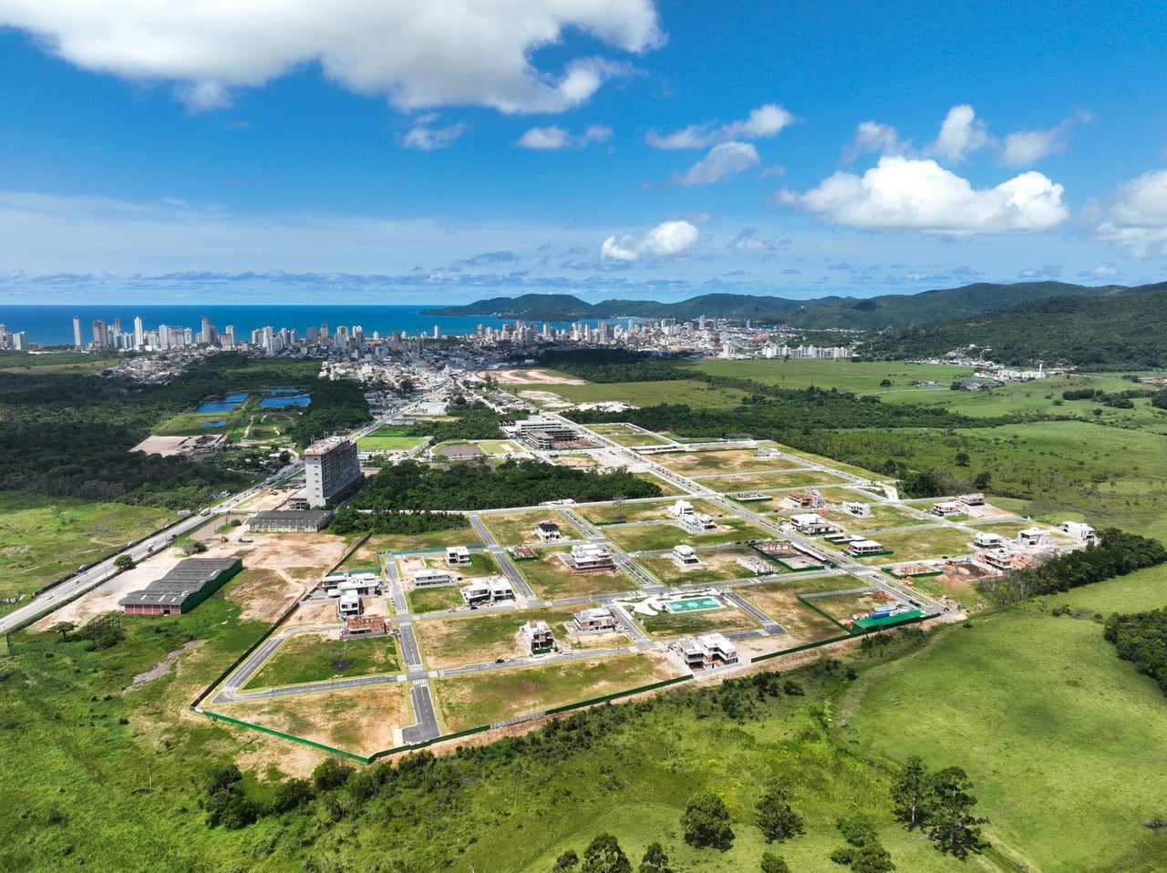 Vista aérea real do VivaPark Porto Belo em obras, com o litoral ao fundo
